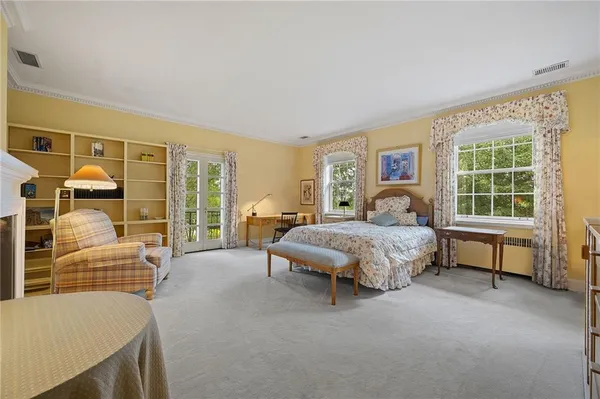 a spacious bedroom with a bed and glass door