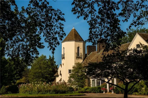a front view of a house with a tree