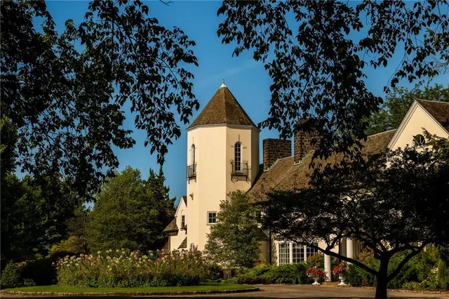 a front view of a house with a tree