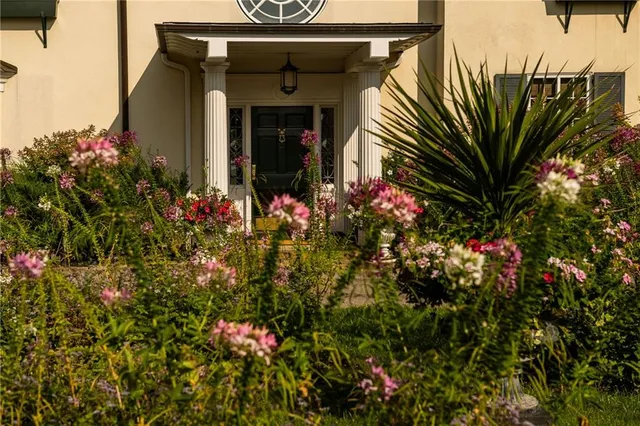 a front view of a house with a lot of flowers