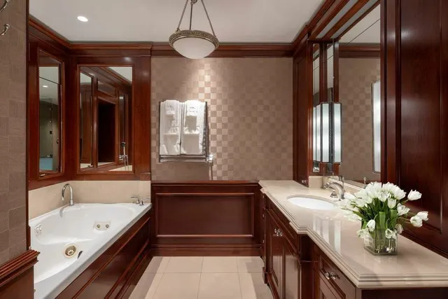 a bathroom with a tub sink shower and mirror
