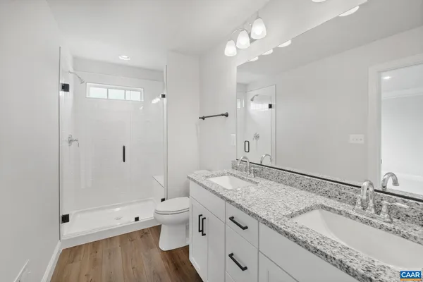 a bathroom with a granite countertop sink a toilet and shower