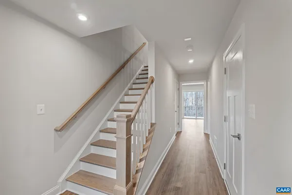 a view of a hallway with wooden floor and entryway