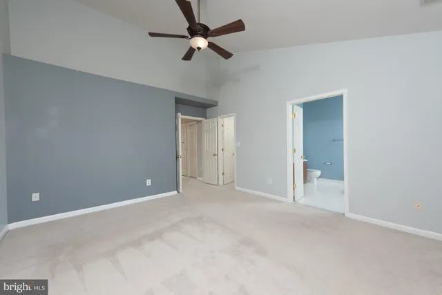 an empty room with chandelier fan
