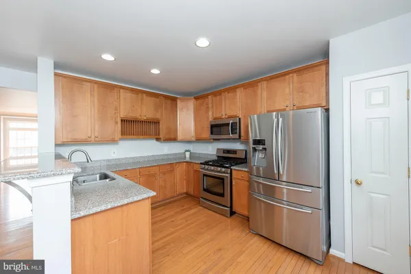 a kitchen with stainless steel appliances granite countertop a refrigerator stove microwave and sink