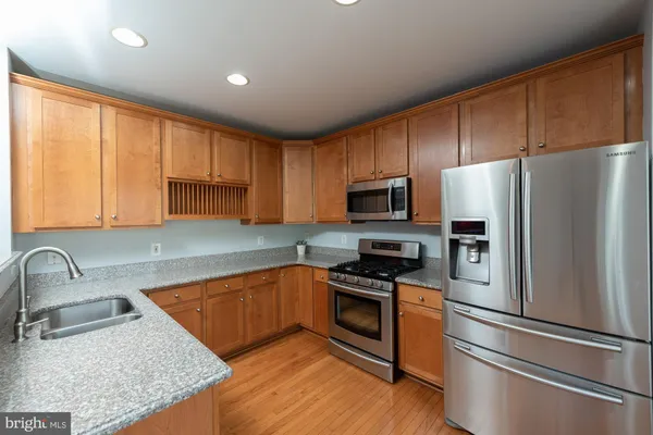 a kitchen with stainless steel appliances granite countertop a refrigerator sink and stove