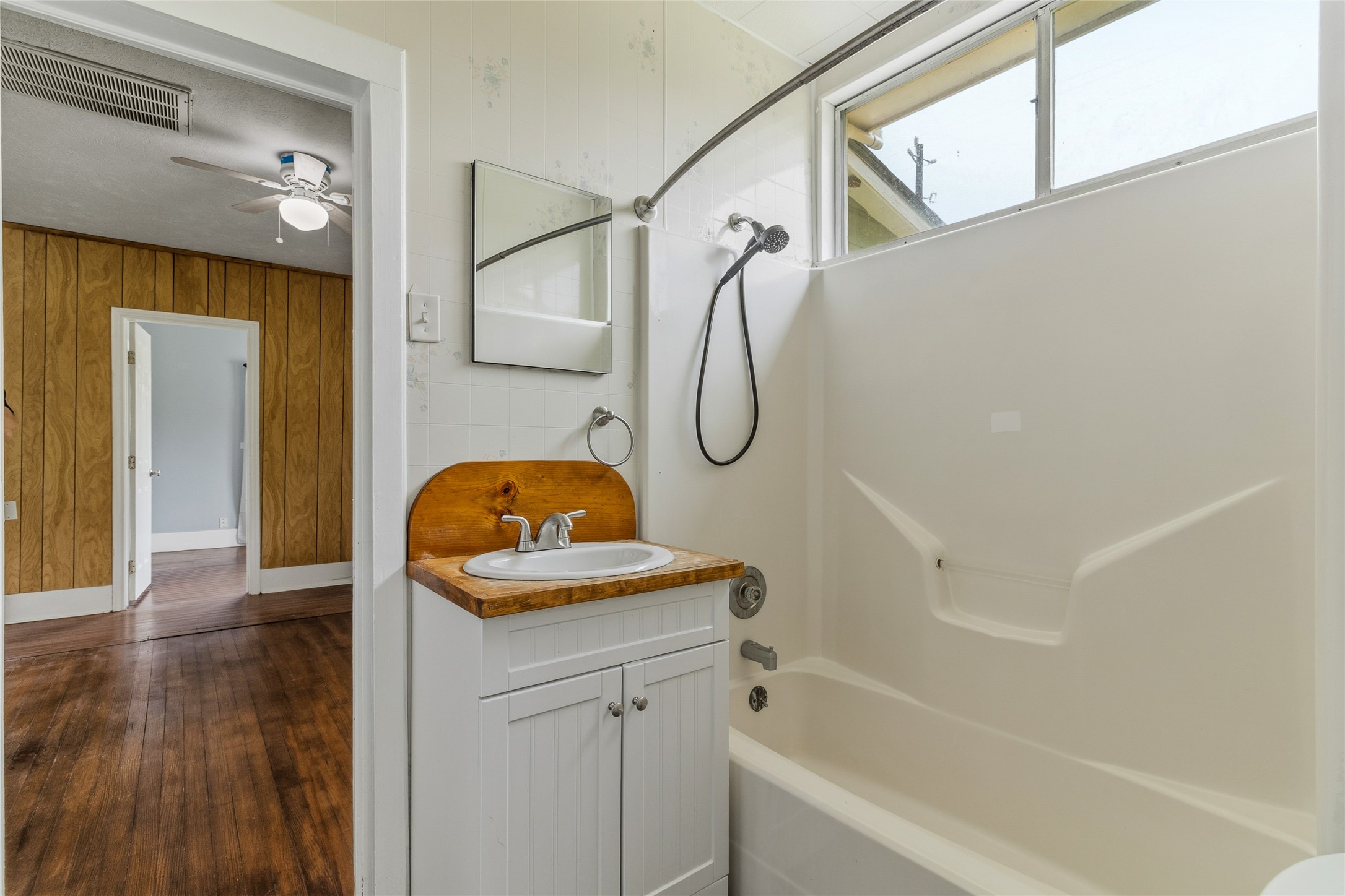 12903 Sandpiper Road Angleton, TX 77515 - Photo 14 of 19 The bathroom features a tub/shower combination, vanity, and abundant built-in storage, offering plenty of space for linens and essentials.