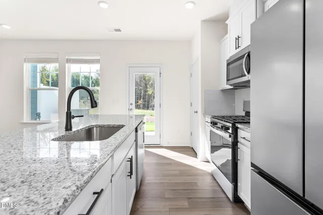 a kitchen with granite countertop a sink and a stove top oven