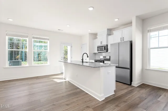 a kitchen with stainless steel appliances a refrigerator sink and cabinets