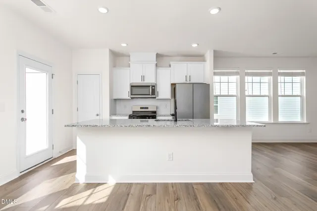 a kitchen with stainless steel appliances a refrigerator and a stove top oven