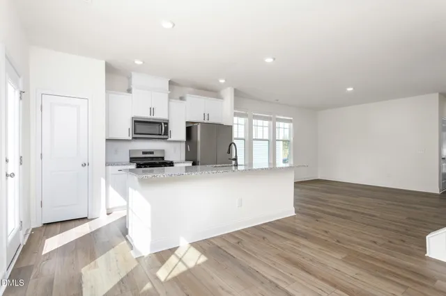 a view of kitchen with kitchen island microwave and cabinets