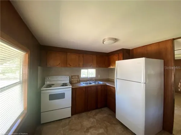 a kitchen with a refrigerator sink stove and cabinets