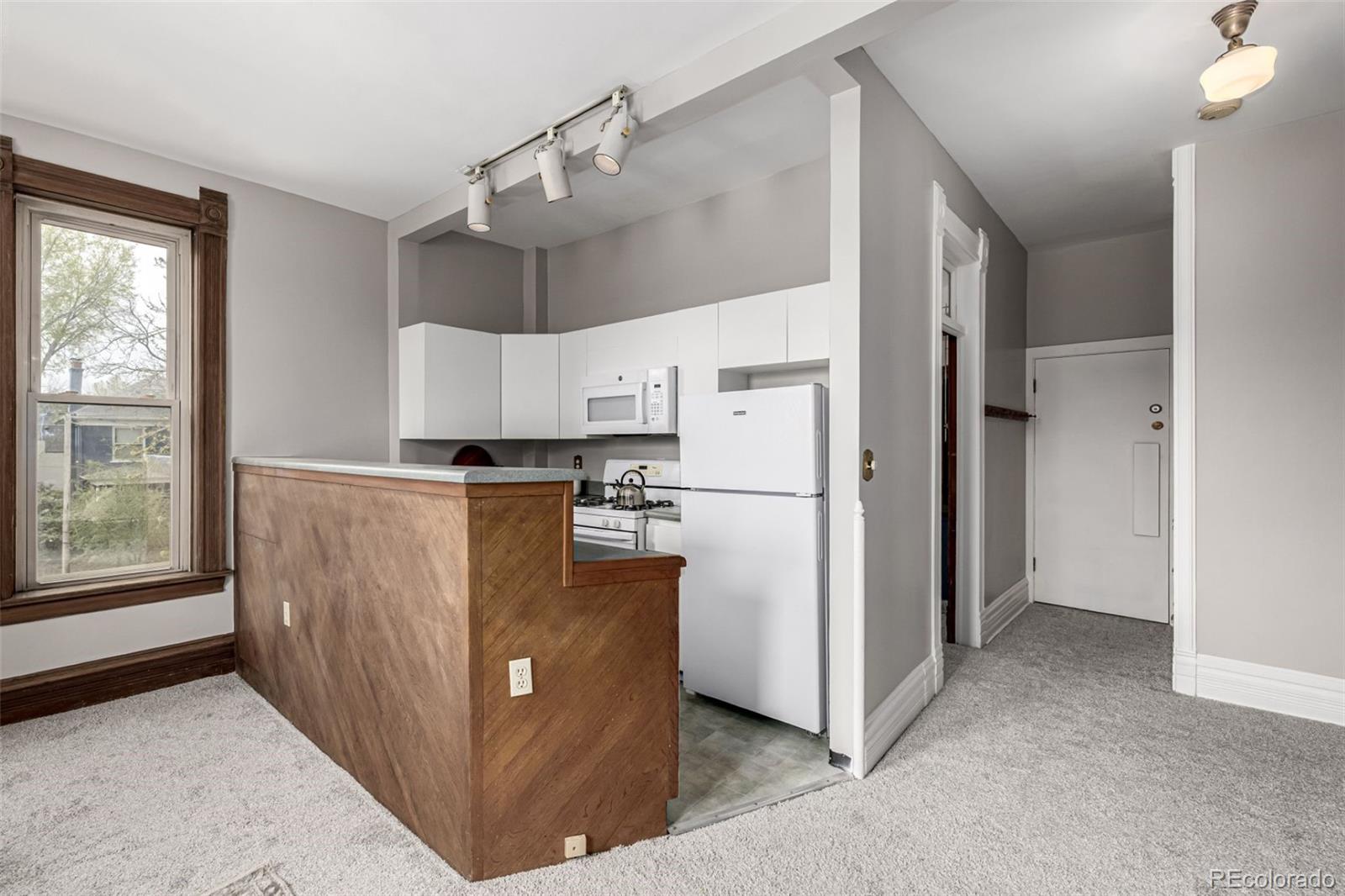 107 Pearl Street, Unit B Denver, CO 80203 - Photo 13 of 39 a view of a kitchen with cabinets and refrigerator