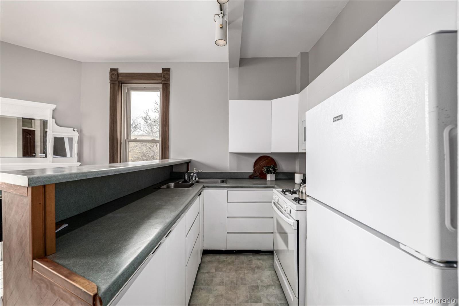 107 Pearl Street, Unit B Denver, CO 80203 - Photo 14 of 39 a kitchen with a stove a sink and a refrigerator