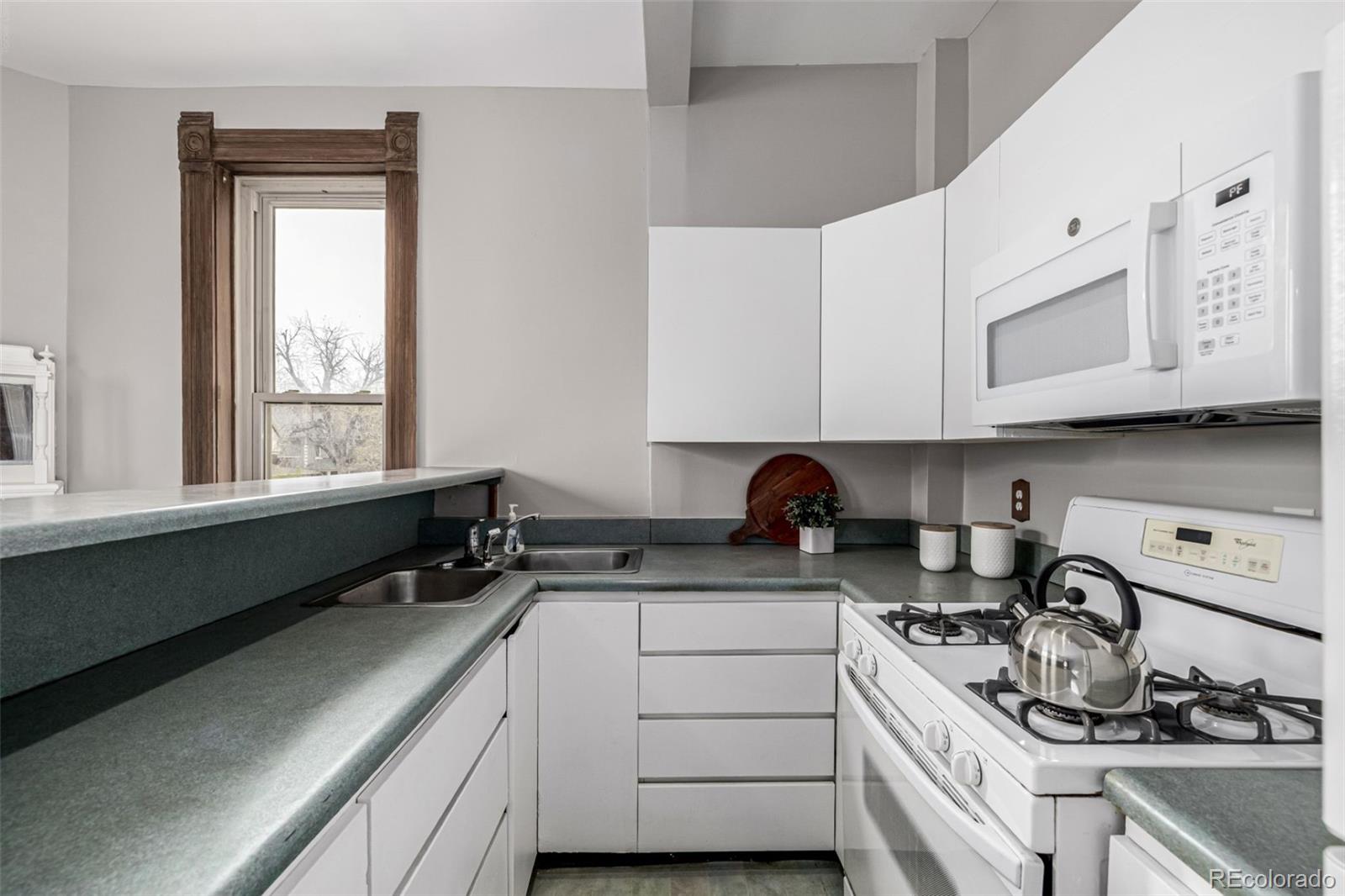 107 Pearl Street, Unit B Denver, CO 80203 - Photo 15 of 39 a kitchen with a sink stove top oven and cabinets