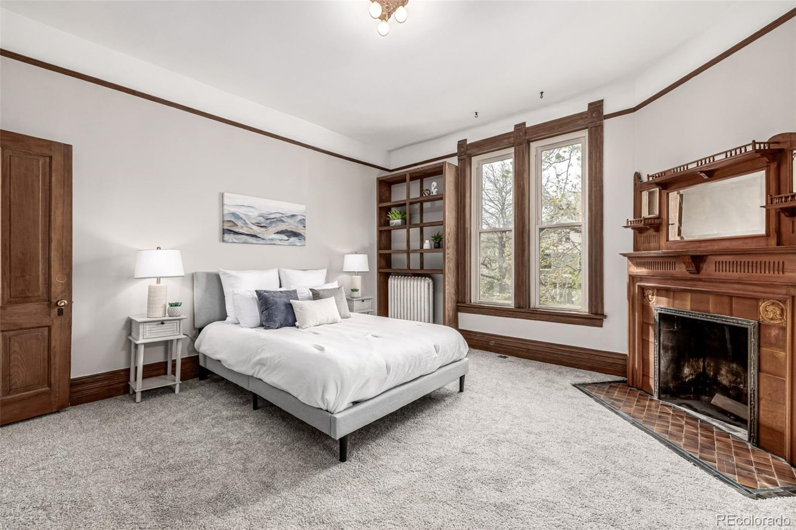 107 Pearl Street, Unit B Denver, CO 80203 - Photo 19 of 39 a spacious bedroom with a bed and a fireplace