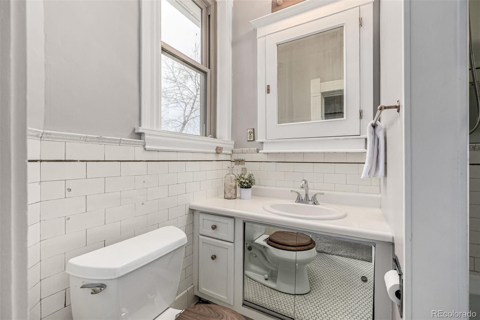 107 Pearl Street, Unit B Denver, CO 80203 - Photo 22 of 39 a bathroom with a toilet sink and mirror