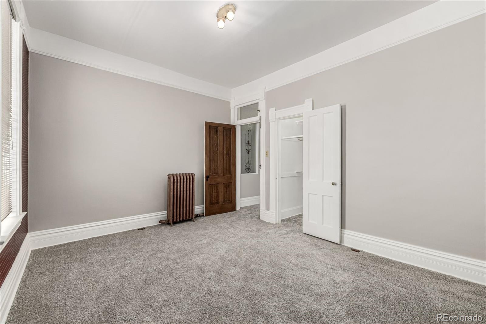 107 Pearl Street, Unit B Denver, CO 80203 - Photo 29 of 39 an empty room with a cabinet and mirrors