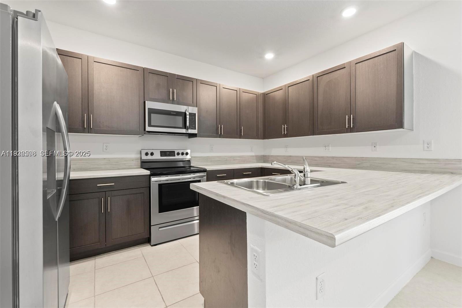 2668 Southeast 19th Street Homestead, FL 33035 - Photo 24 of 37 a kitchen with a stove a sink and a refrigerator