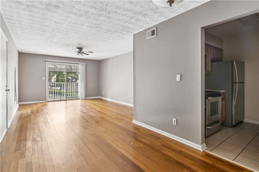 3155 Seven Pines, Unit 303 Atlanta, GA 30339 - Photo 8 of 25 a view of an empty room with wooden floor and a window