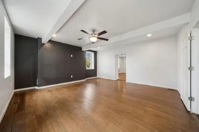 a view of an empty room with a ceiling fan