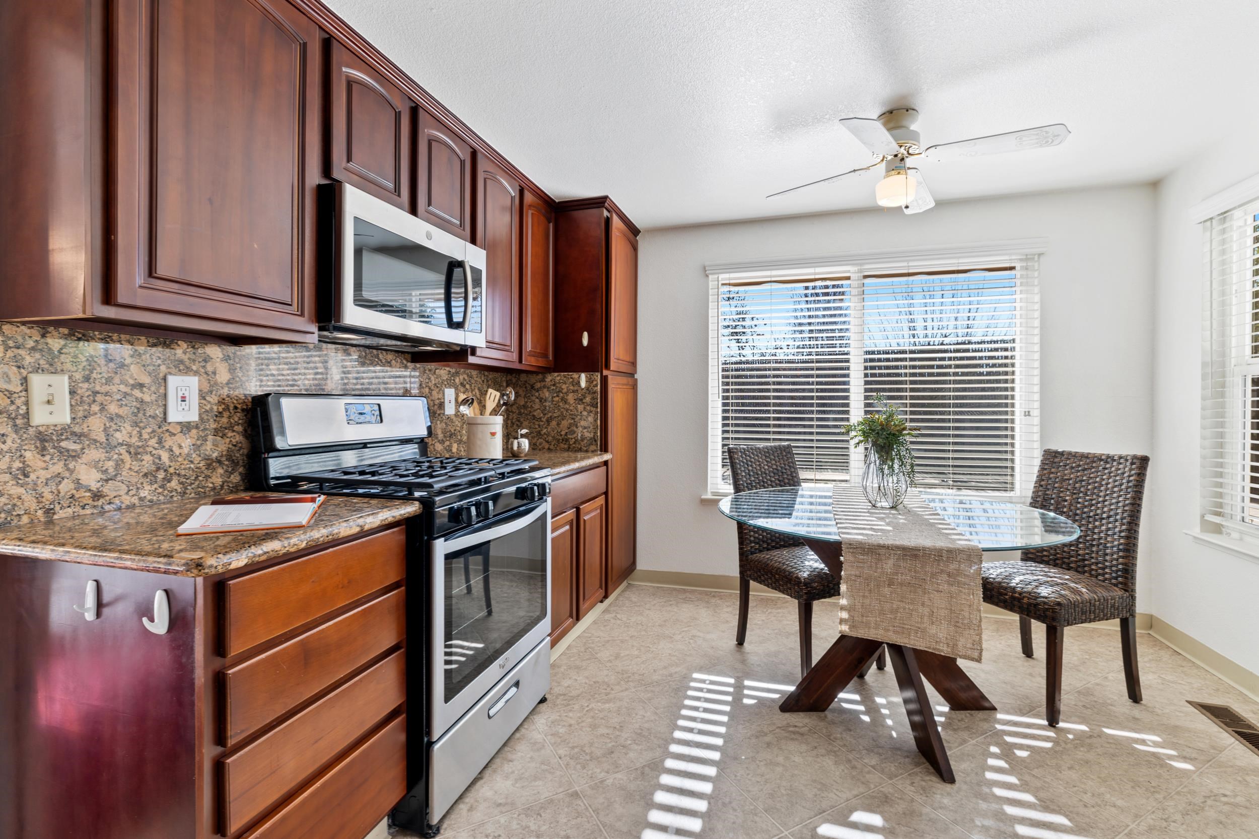 2832 Filbert Street Antioch, CA 94509 - Photo 17 of 40 a kitchen with stainless steel appliances granite countertop a stove top oven a sink dishwasher a dining table and chairs with wooden floor