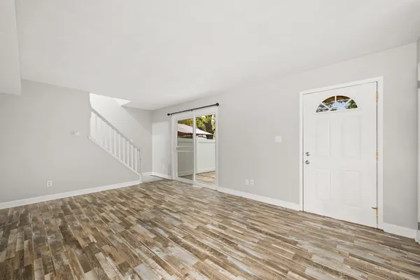 a view of empty room with wooden floor