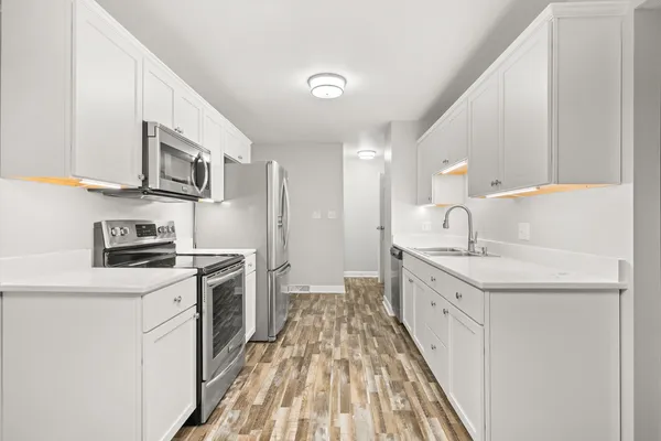 a kitchen with stainless steel appliances granite countertop a sink stove and refrigerator