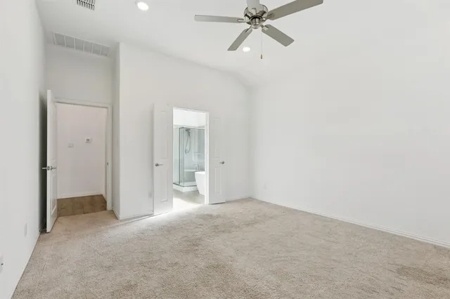 a view of a room with a ceiling fan and closet area