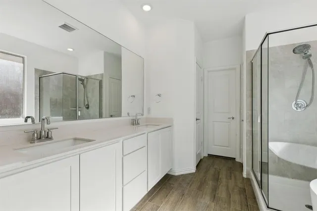 a bathroom with a double vanity sink toilet mirror and shower