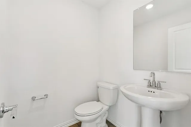 a bathroom with a sink a toilet and mirror