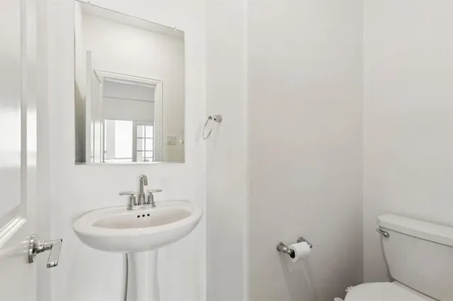 a bathroom with a sink a toilet and mirror