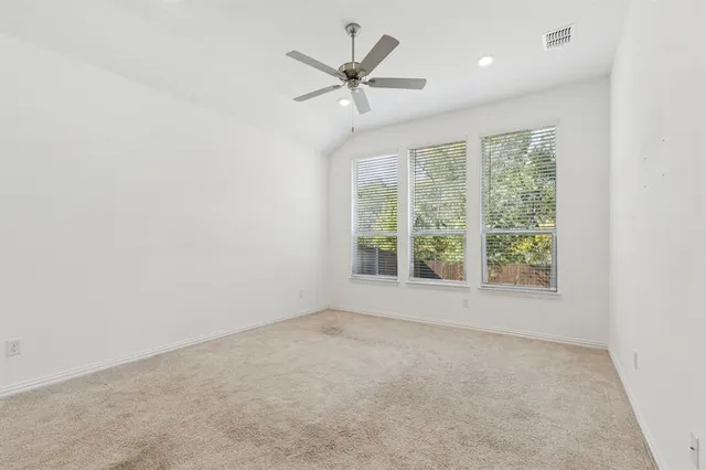 an empty room with a ceiling fan and window