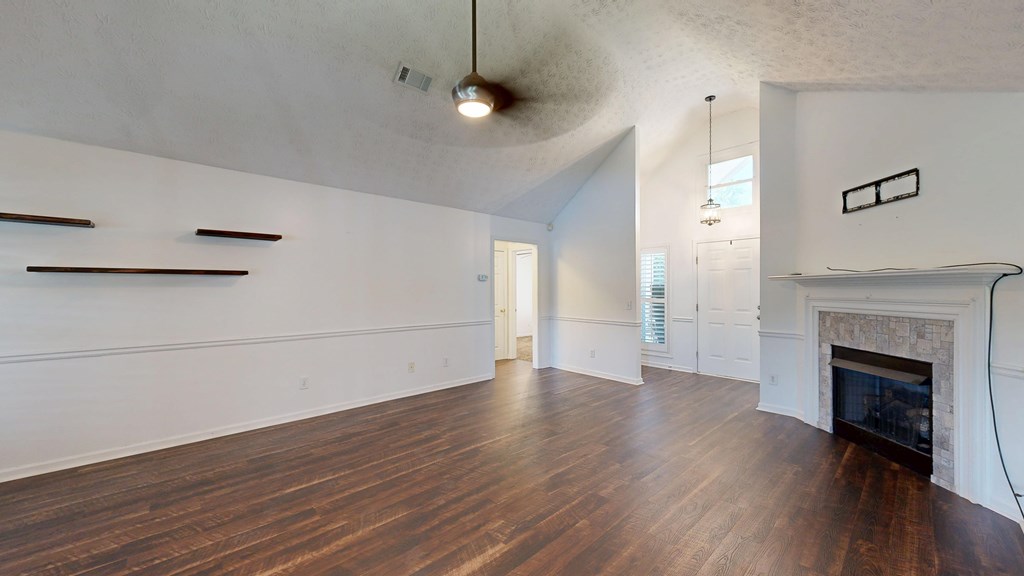 1278 Jones Road Cataula, GA 31804 - Photo 14 of 94 an empty room with wooden floor a ceiling fan a fireplace and windows