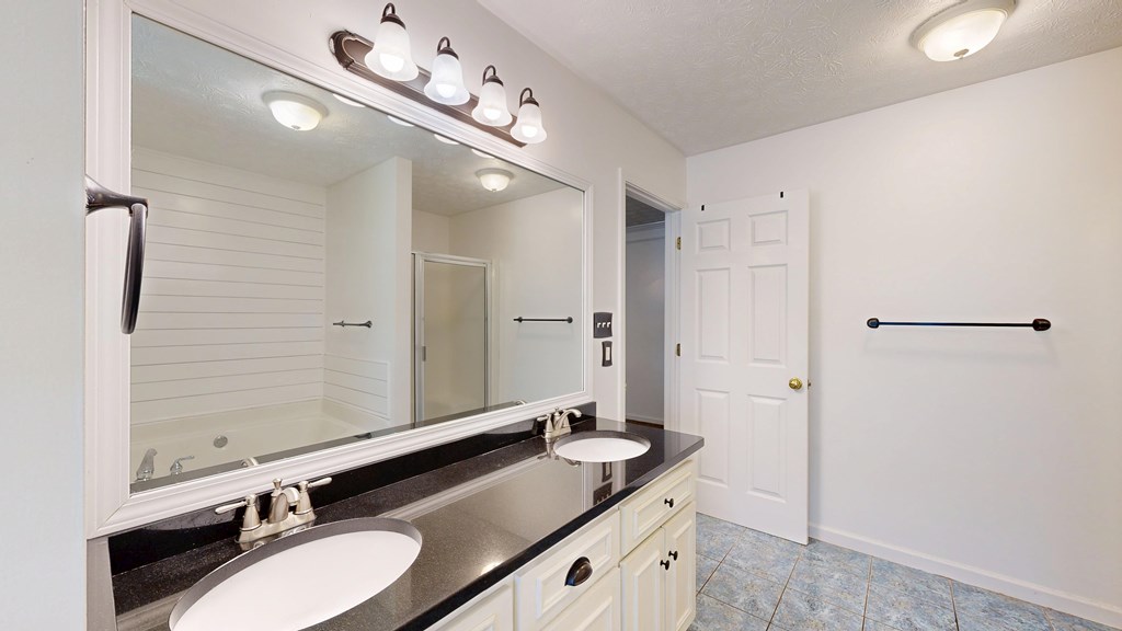1278 Jones Road Cataula, GA 31804 - Photo 34 of 94 a bathroom with a granite countertop double vanity sink and mirror with shower
