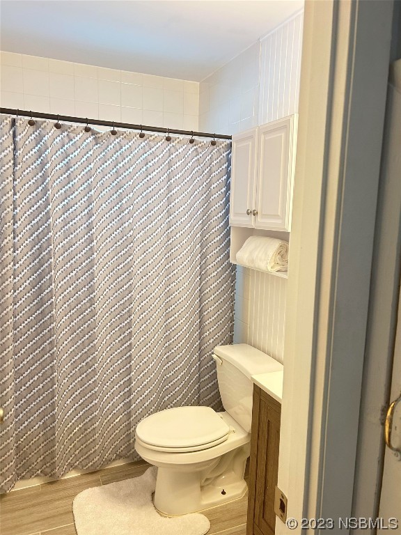 910 Maple Street, Unit A New Smyrna Beach, FL 32169 - Photo 16 of 18 a white toilet sitting next to a shower curtain