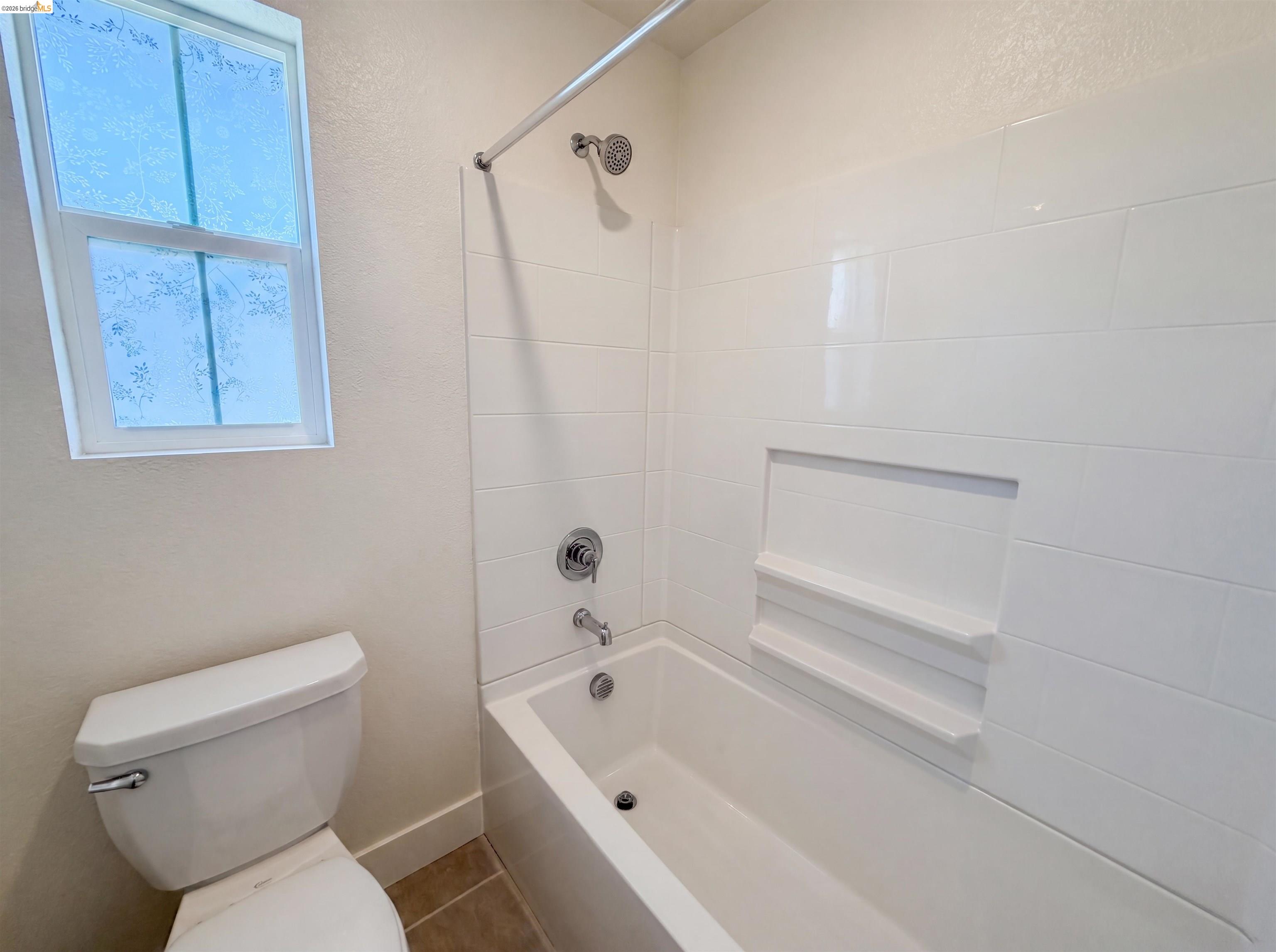 9034 Rudder Way Newark, CA 94560 - Photo 22 of 38 White subway tile tub surround featuring a recessed niche with integrated shelving, chrome fixtures, and a privacy window