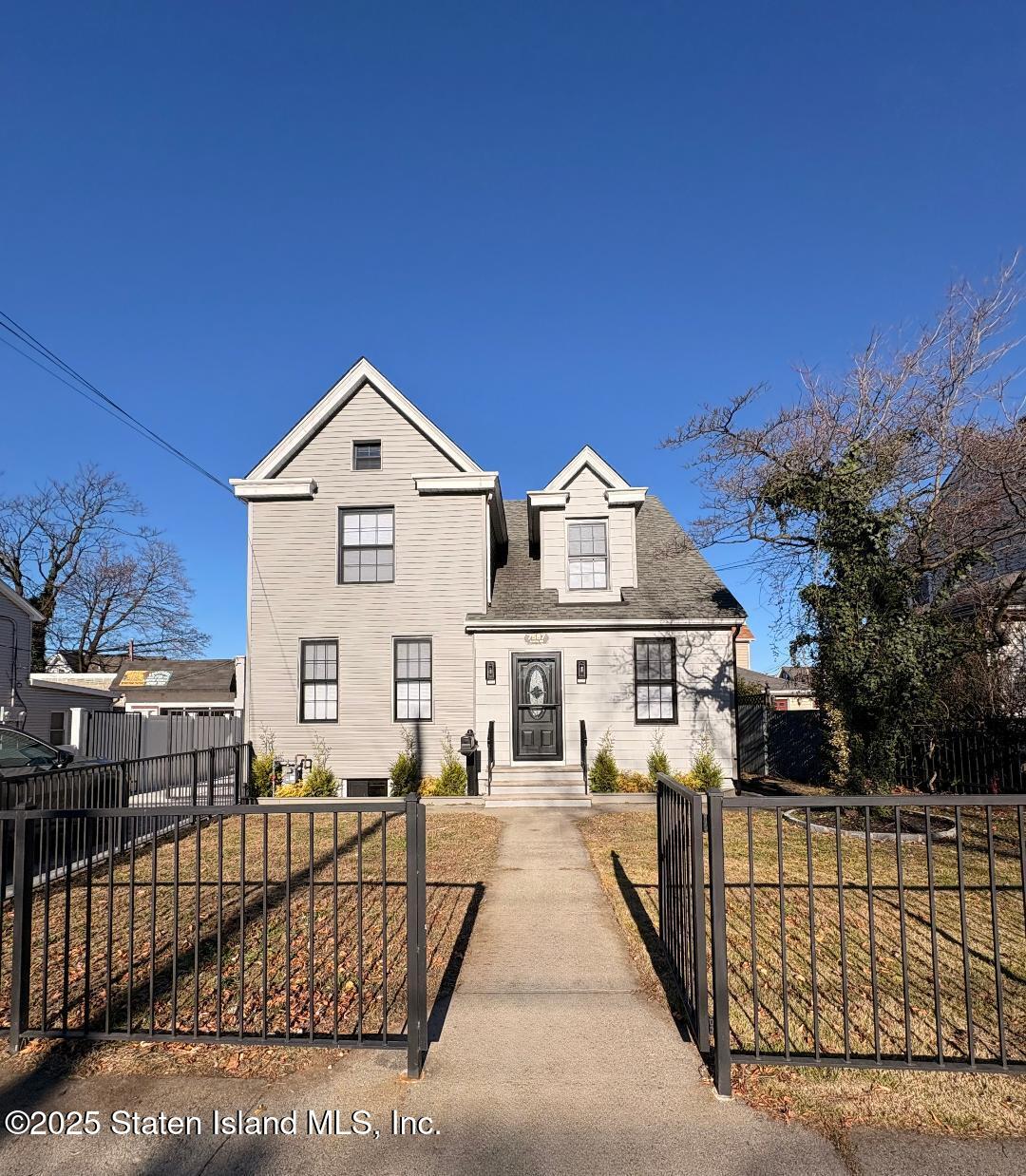 a view of a brick house with large windows and a small yard
