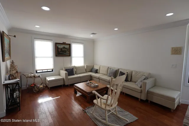 a living room with furniture wooden floor and a flat screen tv