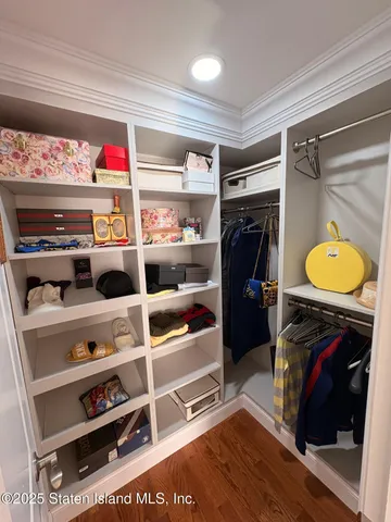 a view of walk in closet with clothes and shoes