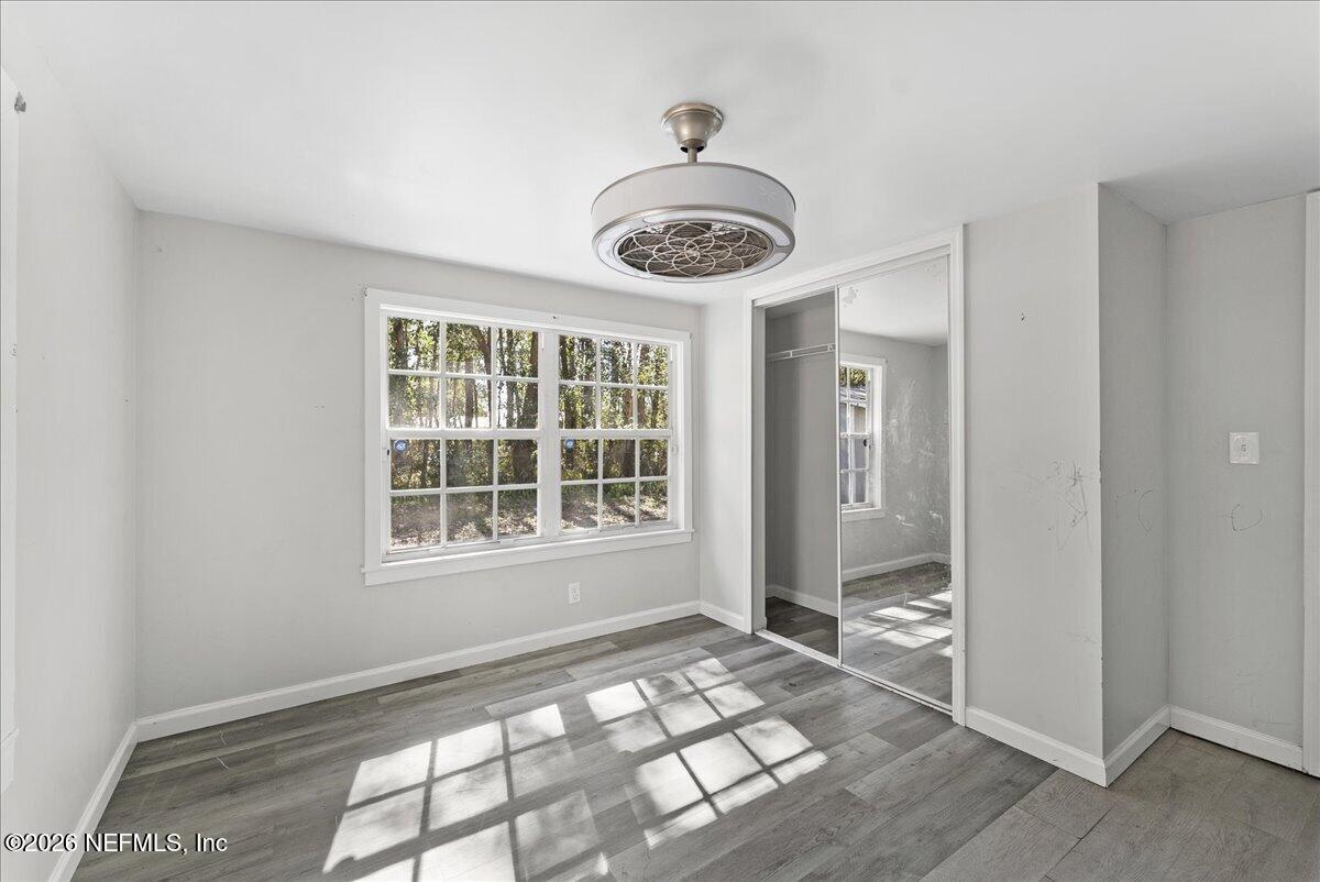 10565 Bessent Road North Jacksonville, FL 32218 - Photo 13 of 27 a view of an empty room with window and wooden floor