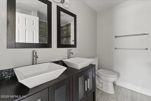 a bathroom with a sink toilet and mirror