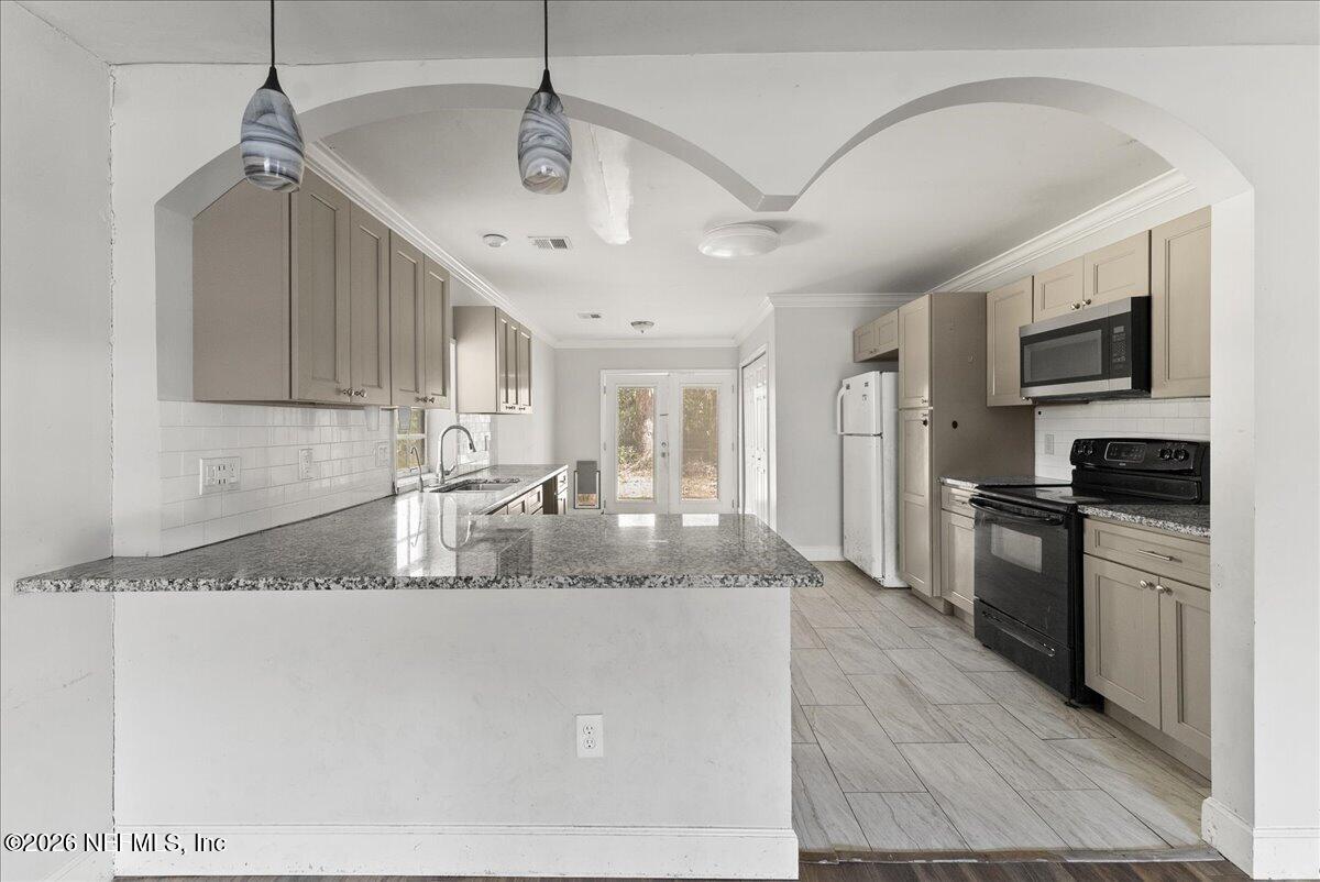 10565 Bessent Road North Jacksonville, FL 32218 - Photo 4 of 27 a large kitchen with granite countertop a sink a counter top space appliances and cabinets