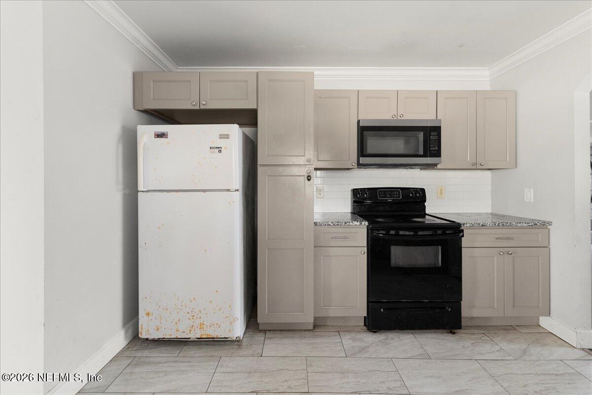 10565 Bessent Road North Jacksonville, FL 32218 - Photo 6 of 27 a kitchen with a refrigerator stove and microwave