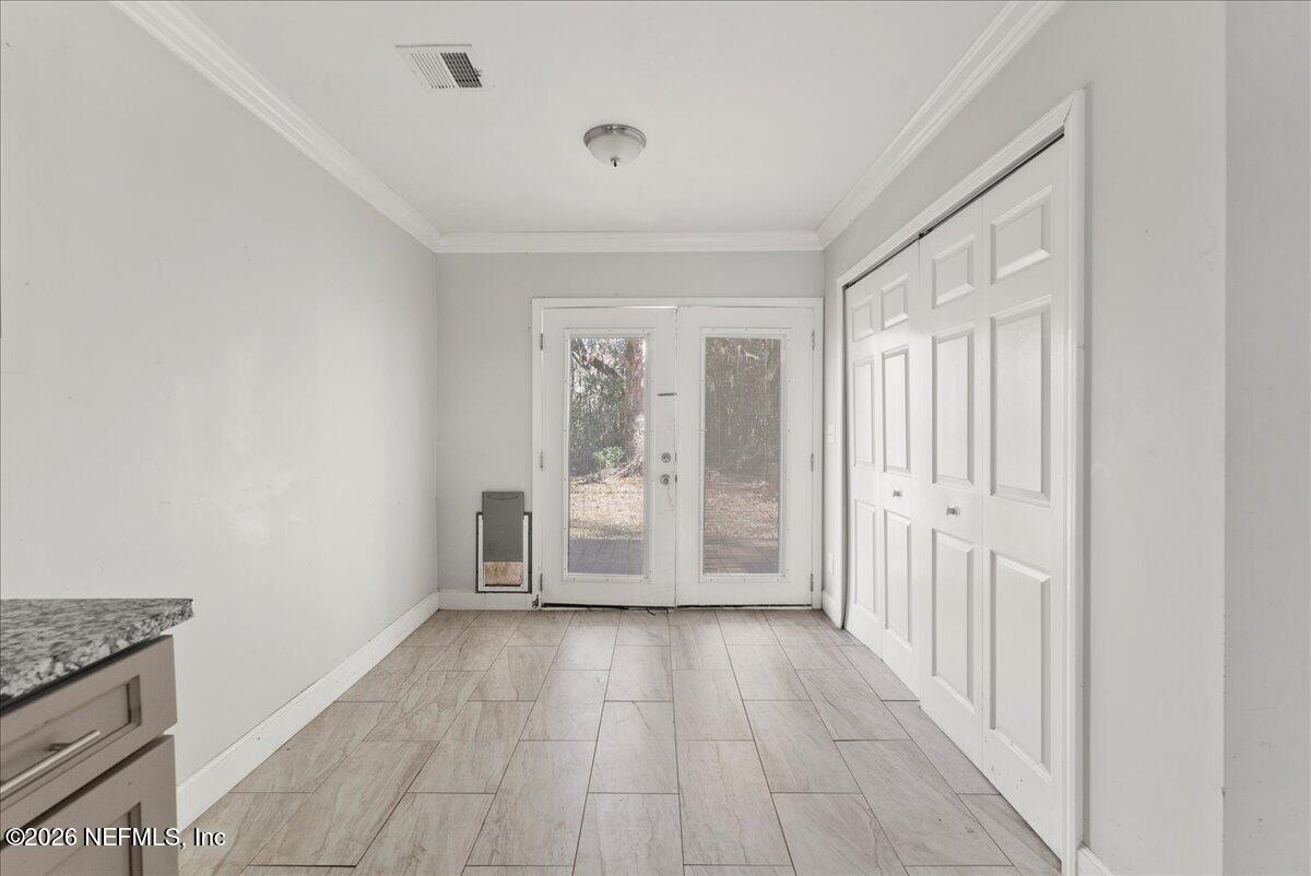 10565 Bessent Road North Jacksonville, FL 32218 - Photo 7 of 27 a view of an empty room with wooden floor and a window