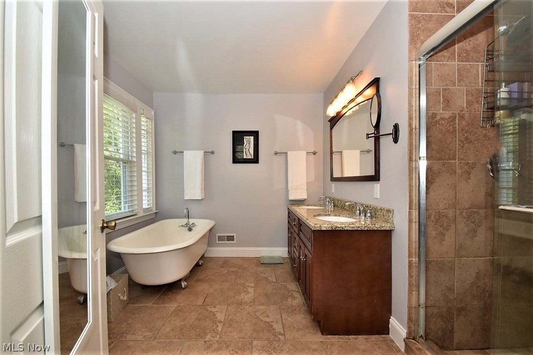 3309 Stockholm Road Cleveland, OH 44120 - Photo 22 of 35 Updated master bathroom with double sink vanity w/ granite countertop, tile lined shower and claw foot tub.