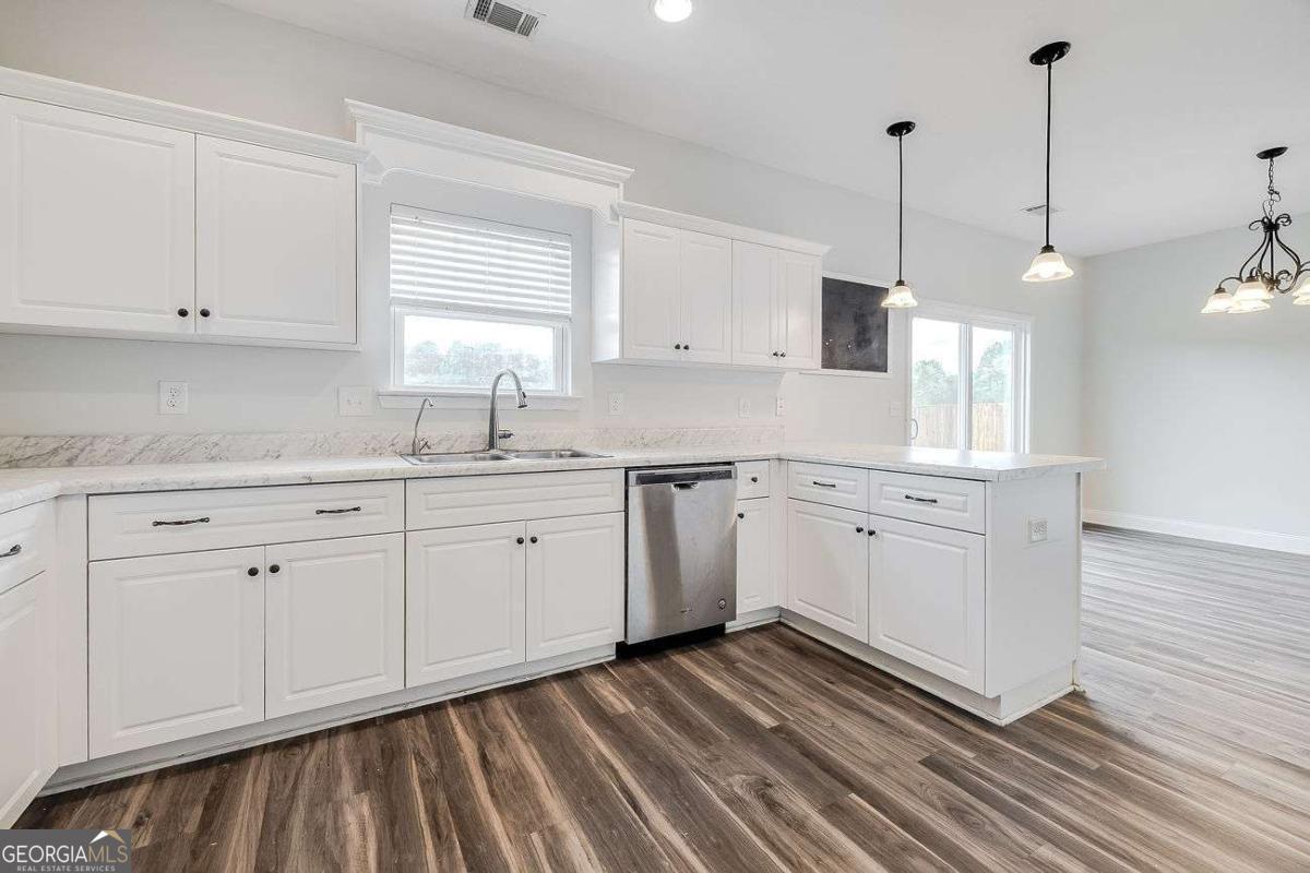 208 Timberlake Lane Guyton, GA 31312 - Photo 11 of 24 a kitchen with cabinets stainless steel appliances a sink and wooden floor
