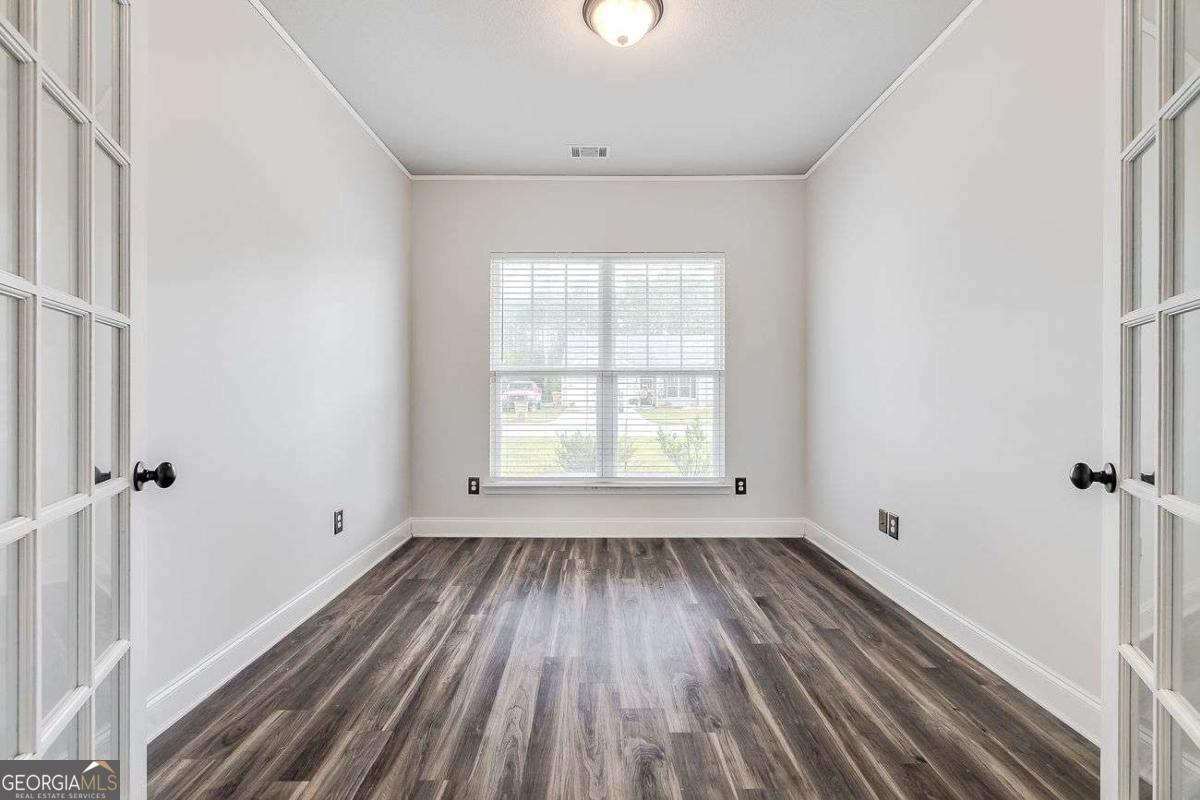 208 Timberlake Lane Guyton, GA 31312 - Photo 6 of 24 an empty room with wooden floor and windows