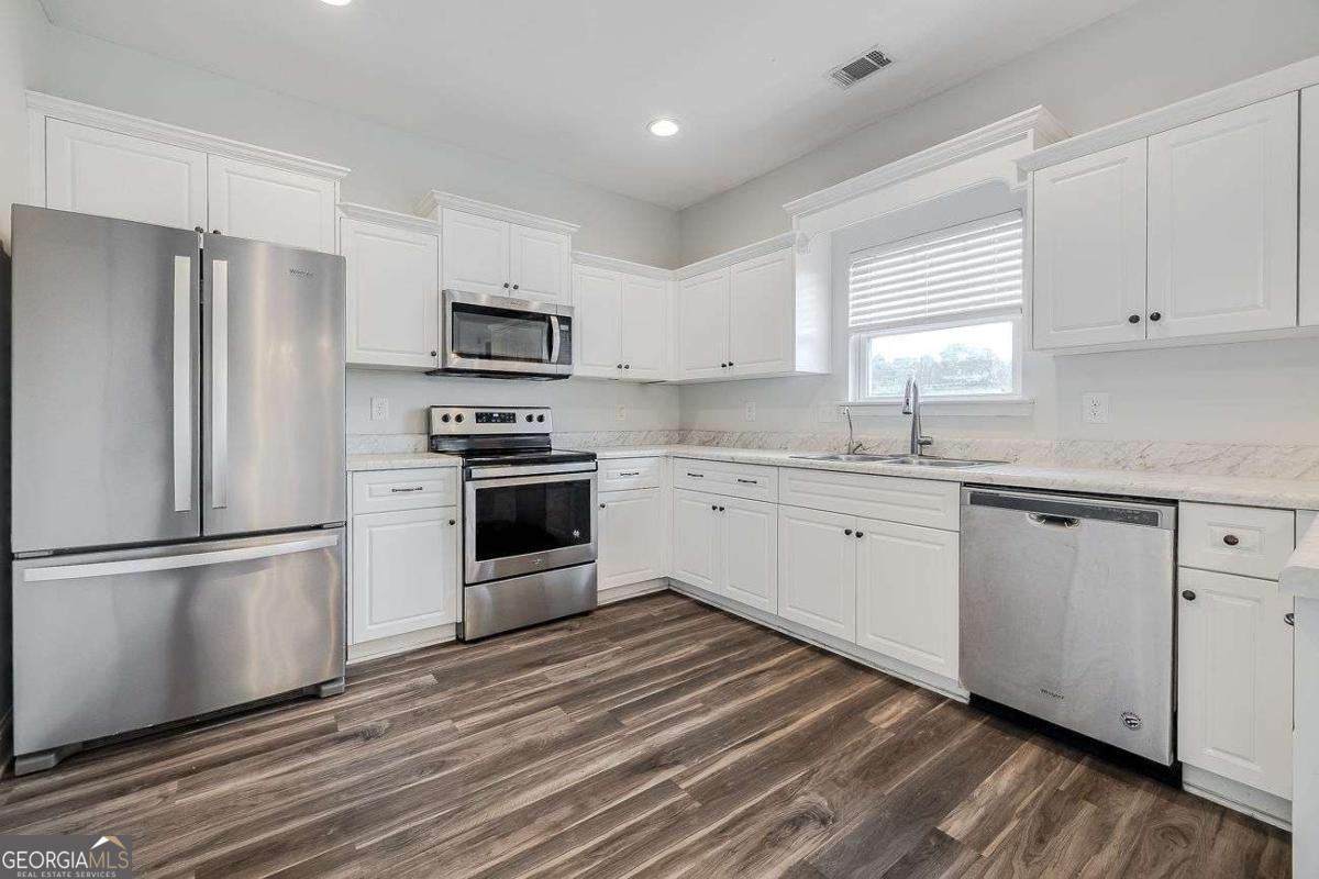 208 Timberlake Lane Guyton, GA 31312 - Photo 9 of 24 a kitchen with stainless steel appliances a refrigerator sink and microwave