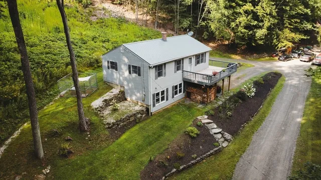 aerial view of a house with a big yard and large trees